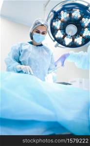 Female surgeon and assistant, professional surgery, operating room. Doctor in uniform performs operation, medical clinic worker, surgical medicine and health, healthcare in hospital. Female surgeon and assistant, professional surgery