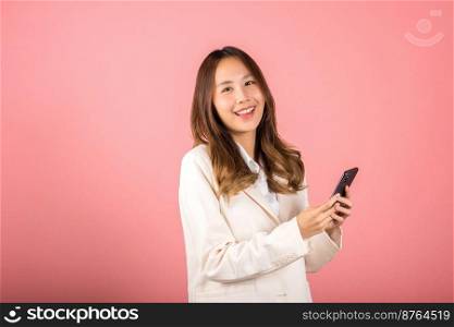 Female surprised and sms chatting internet online on smartphone studio shot isolated on pink background, Happy Asian portrait beautiful cute young woman teen smiling excited hold smart mobile phone