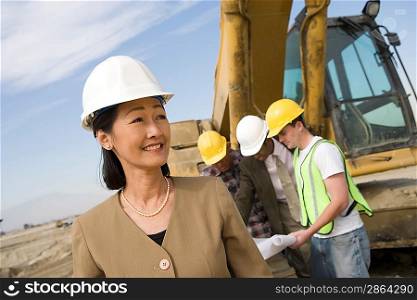 Female surveyor and construction workers on site