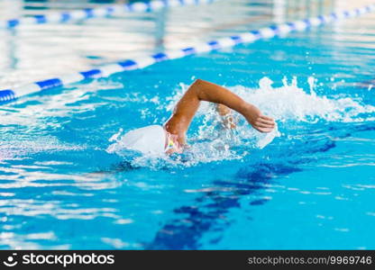 Female swimmer on training in the swimming pool. Front crawl swimming style