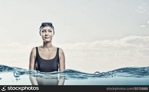 Female swimmer. Portrait of woman swimmer in cap and glasses