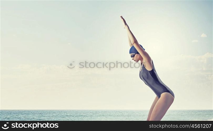 Female swimmer. Young woman competition swimmer in starting pose