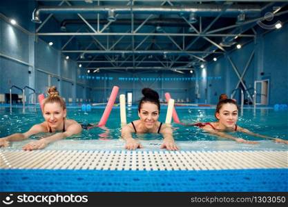 Female swimmers group, aqua aerobics training in the pool. Women in the water, sport swimming fitness workout. Female swimmers group, aqua aerobics training