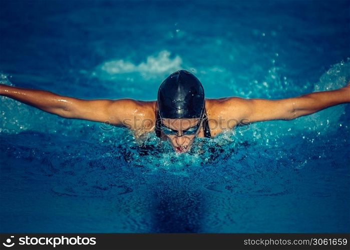 Female swimming butterfly in the pool