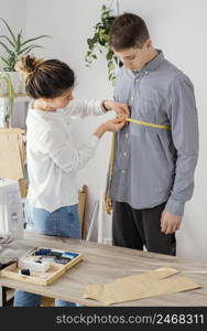 female tailor measuring male clients shirt 2