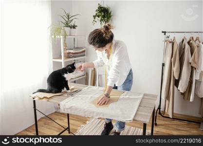 female tailor working studio with cat
