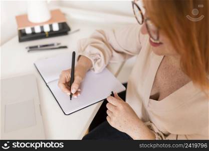 female teacher desk writing agenda during online class