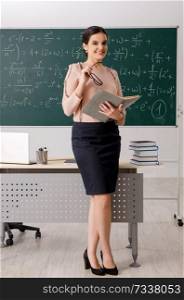 Female teacher standing in front of chalkboard   