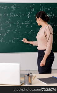 Female teacher standing in front of chalkboard   