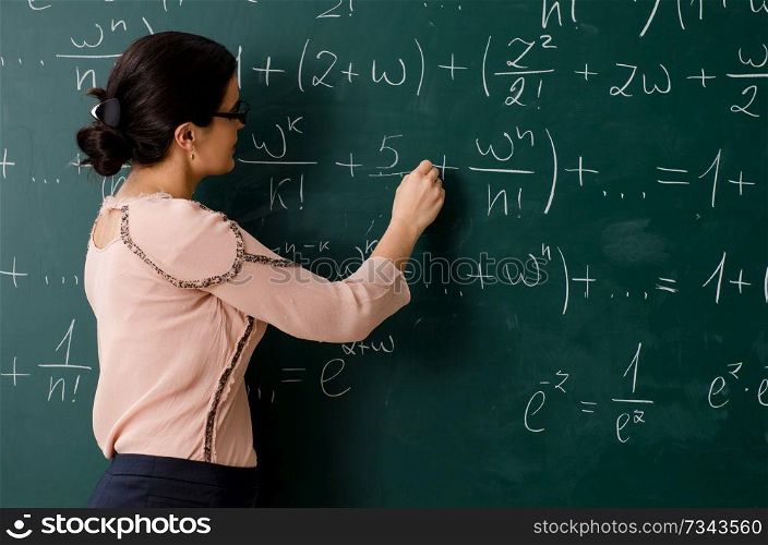 Female teacher standing in front of chalkboard