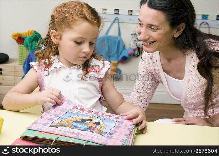 Female teacher teaching her student in a classroom