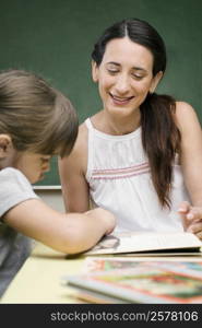 Female teacher teaching her student in a classroom