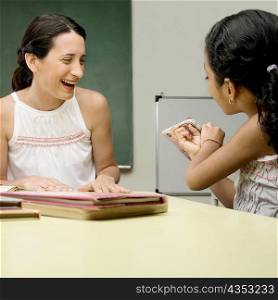 Female teacher teaching her student in a classroom