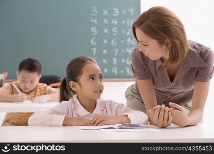 Female teacher teaching her student in a classroom