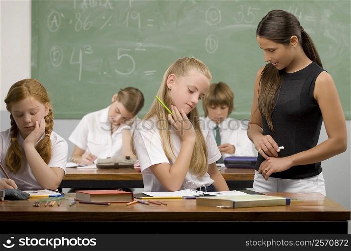 Female teacher teaching students in a classroom