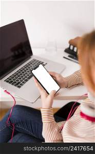 female teacher using laptop smartphone during online class
