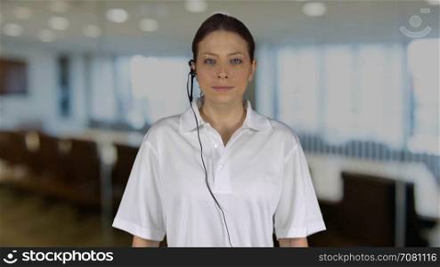 Female technical support crosses arms in an office