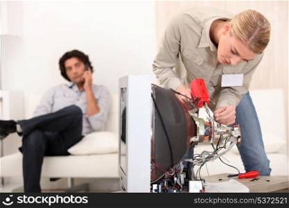 female technician repairing a television