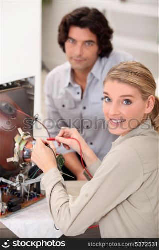 female technician repairing television