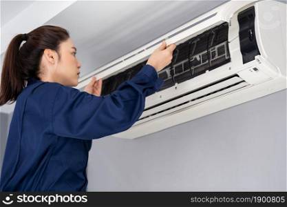 female technician service open the air conditioner indoor for checking and repairing