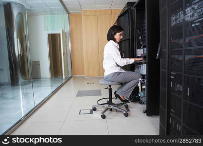 Female technician working in server room