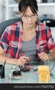 female technician working on power supply from pc