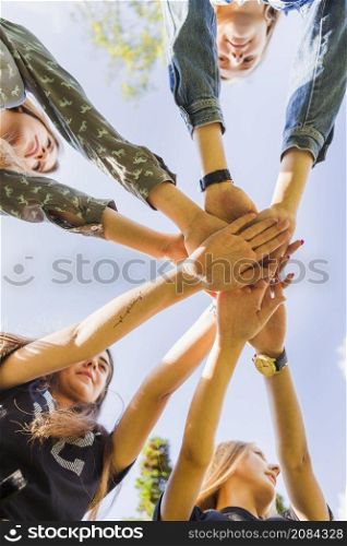 female teen friends stacking hands together