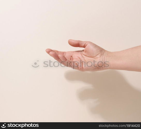 female teen hand to hold something on a beige background. Advertising and product promotion