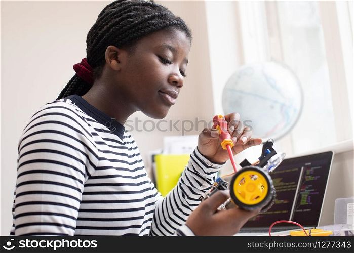 Female Teenage Pupil Building Robot Car In Science Lesson