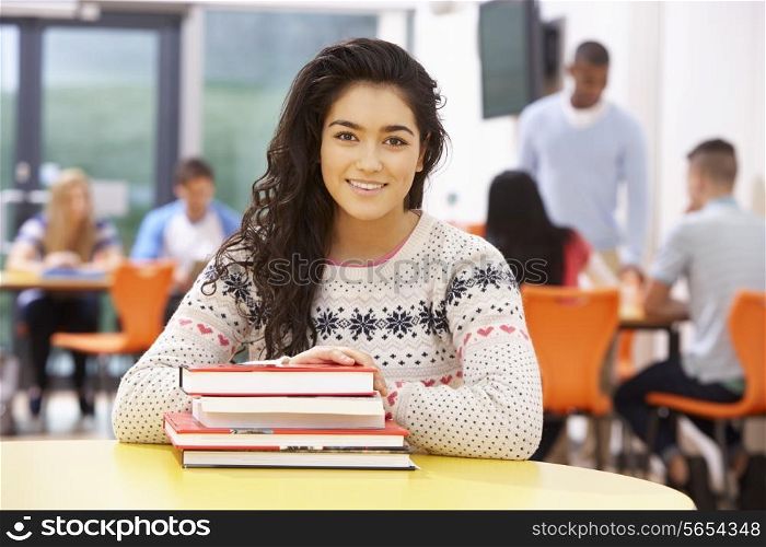 Female Teenage Student In Classroom With Books