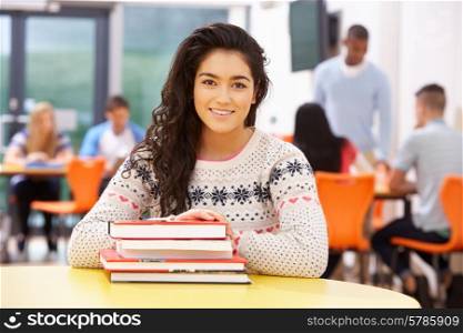 Female Teenage Student In Classroom With Books
