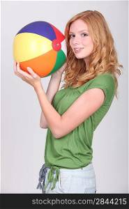 Female teenager holding inflatable beach ball
