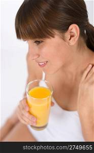 Female teenager with glass of healthy orange juice for breakfast