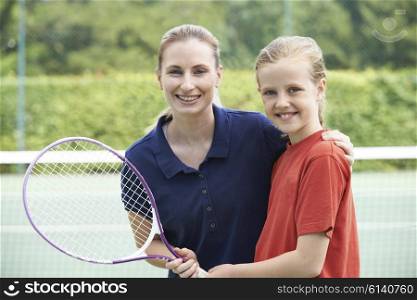 Female Tennis Coach Giving Lesson To Girl