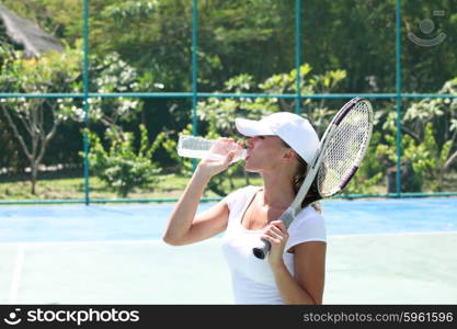 Female tennis player. Female tennis player on court drinking water