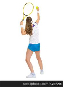 Female tennis player serving ball. rear view