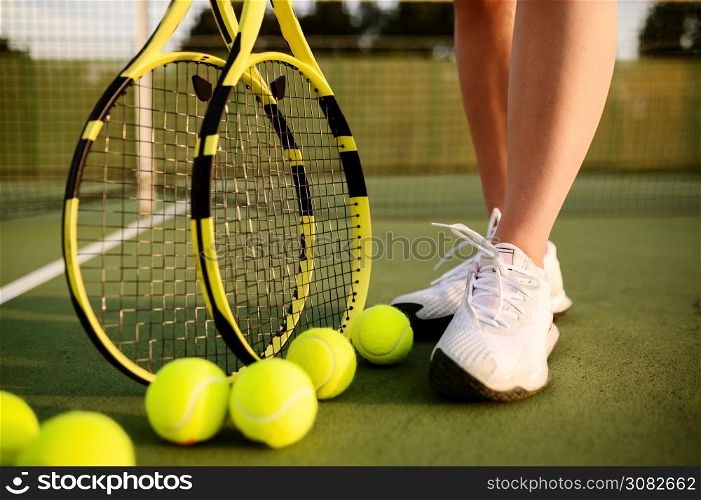 Female tennis player with racket and many balls on outdoor court. Active healthy lifestyle, sport game competition, fitness training with racquet. Female tennis player with racket and many balls