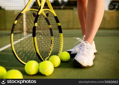 Female tennis player with racket and many balls on outdoor court. Active healthy lifestyle, sport game competition, fitness training with racquet. Female tennis player with racket and many balls