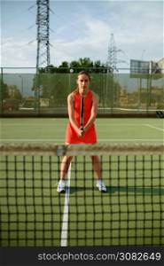 Female tennis player with racket at the net on outdoor court. Active healthy lifestyle, sport game competition, fitness training with racquet. Female tennis player with racket at the net