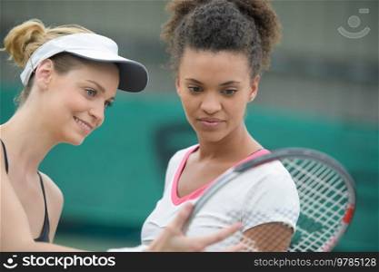 female tennis players checking racquet