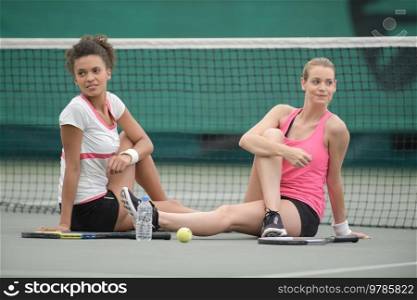 female tennis players stretching outdoors