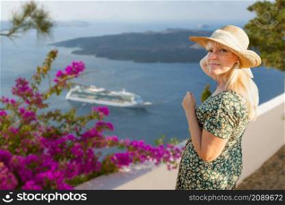 Female Tourist Off the Coast of Santorini Greece Looking Back At Camera.