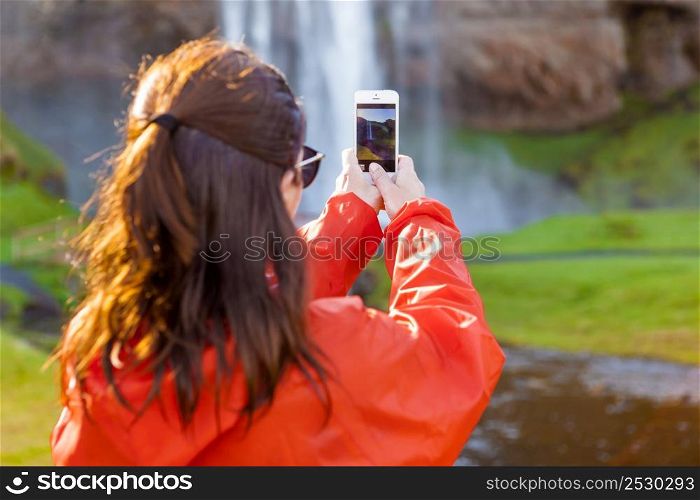 Female tourist taking pcitures with her phone