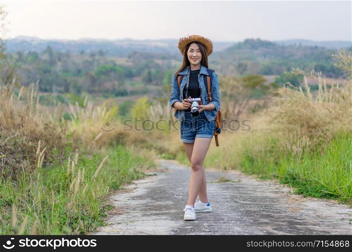 female tourist with backpack and camera in the countryside