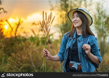 female tourist with backpack and camera in the countryside with sunset