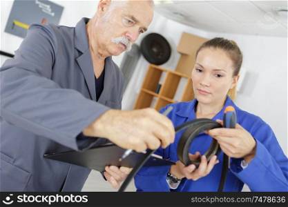female trainee engineer looking at rubber belt