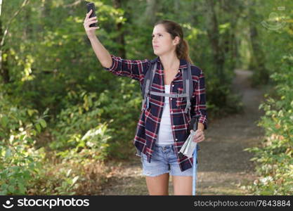 female traveler holding a compass on park