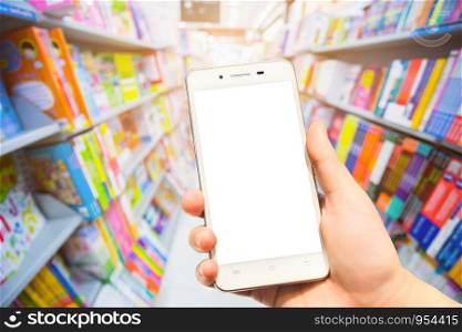 Female use smartphone blurred images in Bokeh Abstract background in magazines from shelf in supermarket background.