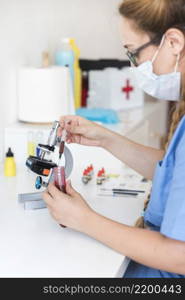 female veterinarian examining blood sample clinic