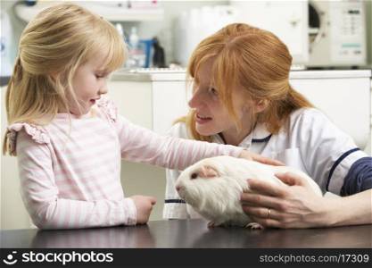 Female Veterinary Surgeon Examining Child&#39;s Guinea Pig In Surgery